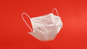 Cloth face covering on a red background