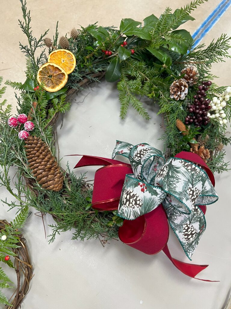 Wreath sample with evergreen, dried oranges, pinecones, and bow